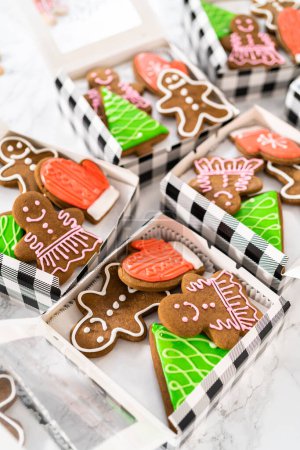 Photo for Packaging a homemade variety of fudge and gingerbread cookies for Christmas food gifts into paper boxes. - Royalty Free Image