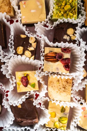 Téléchargez les photos : Emballage d'une variété de caramel maison pour cadeaux alimentaires de Noël dans des boîtes d'étain. - en image libre de droit