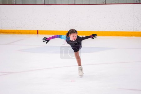 Photo for Little girl practicing before her figure skating competition at the indoor ice rink. - Royalty Free Image