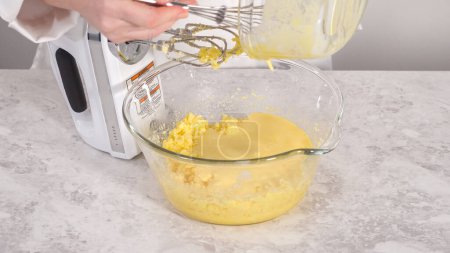 Foto de Paso a paso. Mezclar los ingredientes en un tazón de vidrio para hornear pastel de paquete funfettti. - Imagen libre de derechos