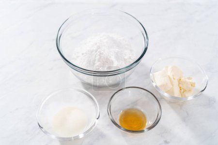 Foto de Measured ingredients in glass mixing bowls to make cream cheese glaze. - Imagen libre de derechos