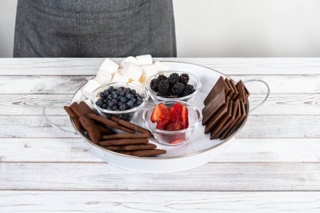 Photo for Arranging fruit smores charcuterie board on a white tray. - Royalty Free Image
