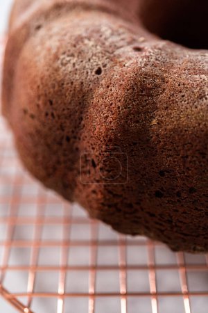 Téléchargez les photos : Refroidissement gâteau bundt en velours rouge fraîchement cuit sur un comptoir de cuisine. - en image libre de droit