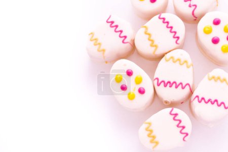Foto de Pasteles petit huevo de Pascua hechos con capas de pastel de vainilla y tarta, mermelada de frambuesa
. - Imagen libre de derechos
