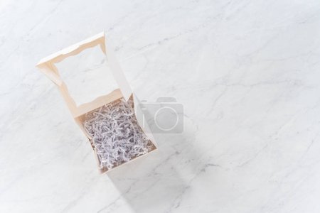 Photo for Flat lay. Empty white paper gift box filled with white paper shred. - Royalty Free Image