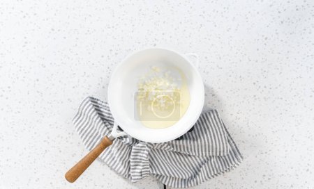 Foto de Acostado. Freír cebolla en una sartén antiadherente para hacer empanadas de desayuno con huevos y batata. - Imagen libre de derechos