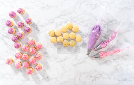 Foto de Acostado. Piping ombre crema de mantequilla rosa glaseado en mini cupcakes de vainilla. - Imagen libre de derechos