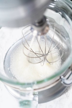 Téléchargez les photos : Mélange d'ingrédients dans un mélangeur de cuisine pour cuire des biscuits meringués de Pâques. - en image libre de droit