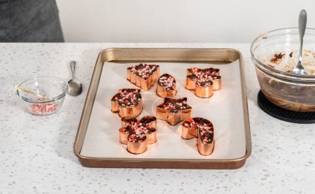 Téléchargez les photos : Remplir le couteau à biscuits avec le mélange de caramel pour préparer le biscuit de Noël-cutter caramel à la menthe poivrée. - en image libre de droit