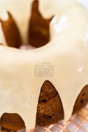 Photo for Pouring homemade eggnog glaze over freshly baked eggnog bundt cake. - Royalty Free Image