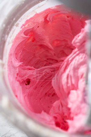 Téléchargez les photos : Mélange d'ingrédients dans un mélangeur électrique de cuisine pour faire ombre rose crème au beurre glaçage. - en image libre de droit
