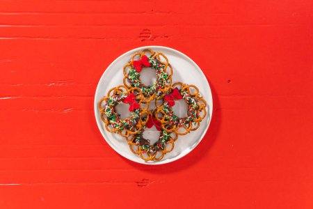 Foto de Flat lay. Chocolate pretzel Christmas wreath on a white plate. - Imagen libre de derechos