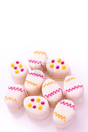 Photo for Easter egg petit cakes made with layers of vanilla cake and tart, raspberry jam. - Royalty Free Image