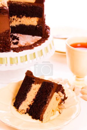 Photo for Peanut butter mousse cake with two layers of chocolate cake, filled and topped with peanut butter mousse and covered in chocolate buttercream. - Royalty Free Image