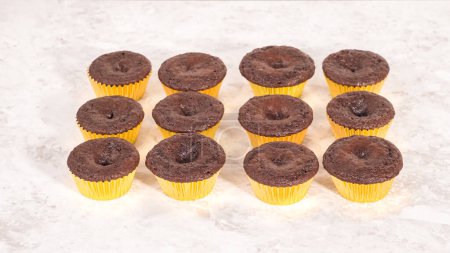 Téléchargez les photos : Pas à pas. Refroidissement cupcakes au chocolat fraîchement cuits à décorer avec glaçage à la crème au beurre. - en image libre de droit
