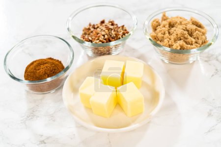 Téléchargez les photos : Ingrédients mesurés dans des bols à mélanger en verre pour cuire des petits gâteaux à la cannelle sans levure. - en image libre de droit