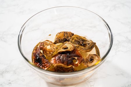 Téléchargez les photos : Tremper les champignons sauvages déshydratés dans un bol de mélange en verre avec de l'eau chaude. - en image libre de droit