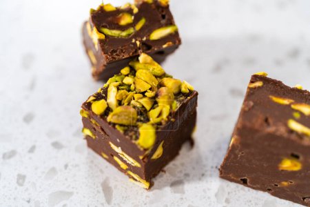 Foto de Homemade chocolate pistachio fudge square pieces on a kitchen counter. - Imagen libre de derechos