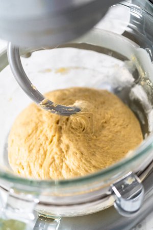 Photo for Mixing ingredients in kitchen mixer to bake mini Easter bread kulich. - Royalty Free Image
