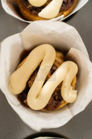 Foto de Adorne cupcakes de canela sin levadura con glaseado de queso crema de la bolsa de tuberías. - Imagen libre de derechos