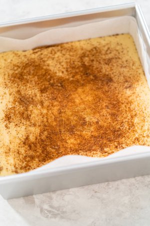 Photo for Freshly made homemade eggnog fudge in a square cheesecake baking pan lined with parchment paper. - Royalty Free Image