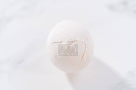 Téléchargez les photos : Éplucher les œufs durs au comptoir de la cuisine en marbre. - en image libre de droit