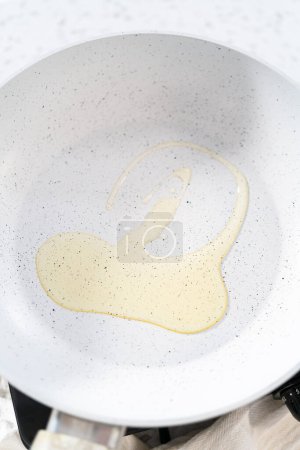 Photo for Frying eggs on a nonstick frying pan to make breakfast egg and sprout sandwich. - Royalty Free Image