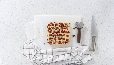Téléchargez les photos : Pose plate. Caramel aux noix de pécan au chocolat blanc à découper en petits morceaux. - en image libre de droit
