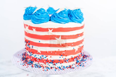Foto de Decoración de pastel de chocolate con glaseado de crema de mantequilla blanca, roja y azul para la celebración del 4 de julio. - Imagen libre de derechos