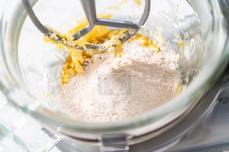 Téléchargez les photos : Mélange d'ingrédients dans un mélangeur de stand de cuisine pour cuire des biscuits aux noix de raisin à l'avoine molle. - en image libre de droit