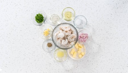 Téléchargez les photos : Pose plate. Ingrédients mesurés dans des bols à mélanger en verre pour préparer la farine de crevettes congelées. - en image libre de droit