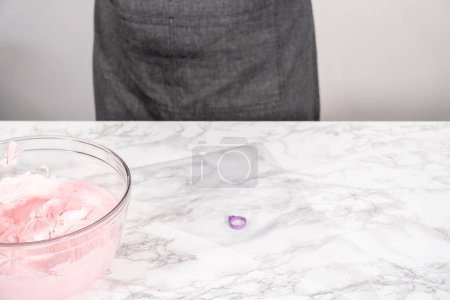 Foto de Frosting crema de mantequilla rosa en una bolsa de tuberías en un ocunter de cocina. - Imagen libre de derechos
