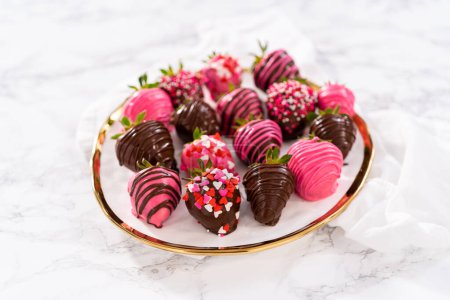 Photo for Gourmet chocolate-covered strawberries decorated with chocolate drizzles and sprinkles on a white plate. - Royalty Free Image