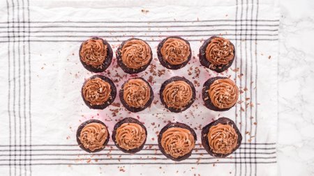Photo for Flat lay. Step by step. Shaving chocolate bar on top of chocolate cupcakes frosted with chocolate ganache frosting. - Royalty Free Image
