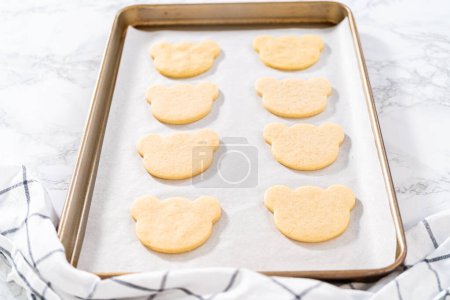 Foto de Freshly baked panda-shaped shortbread cookies on a baking sheet. - Imagen libre de derechos