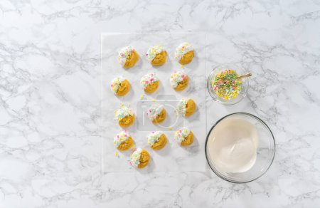Photo for Lemon Cookies with White Chocolate. Flat lay. Dipping lemon cookies into melted white chocolate and decorating them with Easter sprinkles. - Royalty Free Image