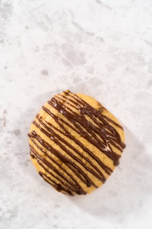 Foto de Galletas de plátano recién horneadas con llovizna de chocolate en un mostrador de cocina. - Imagen libre de derechos