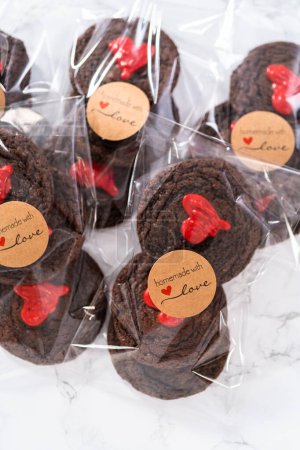 Photo for Chocolate cookies with chocolate hearts for Valentines Day packaged in plastic gift bags. - Royalty Free Image