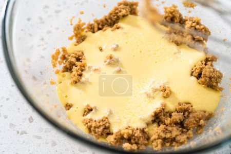 Photo for Mixing ingredients with a hand mixer in a large mixing bowl to bake dulce de leche cupcakes. - Royalty Free Image