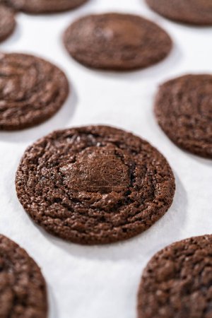 Téléchargez les photos : Refroidissement des biscuits au chocolat fraîchement cuits avec des cœurs de chocolat pour la Saint-Valentin sur un comptoir de cuisine. - en image libre de droit