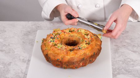 Photo for Step by step. Creating holes for the buttercream filling in funfettti bundt cake. - Royalty Free Image