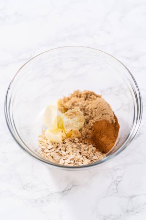 Photo for Mixing ingredients in a large glass mixing bowl to prepare cinnamon crumb topping. - Royalty Free Image