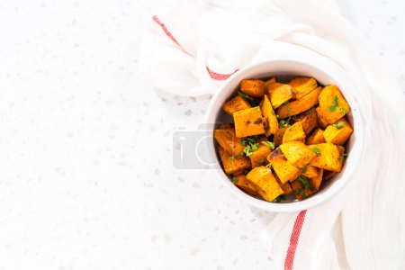 Téléchargez les photos : Servir des patates douces rôties au four dans un bol en céramique blanche. - en image libre de droit