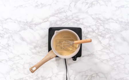 Photo for Flat lay. Prepare toffee glaze in a small sauce pan over an electric stove. - Royalty Free Image