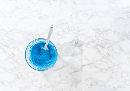 Photo for Flat lay. Mixing food coloring into the buttercream frosting to decorate American flag mini cupcakes. - Royalty Free Image