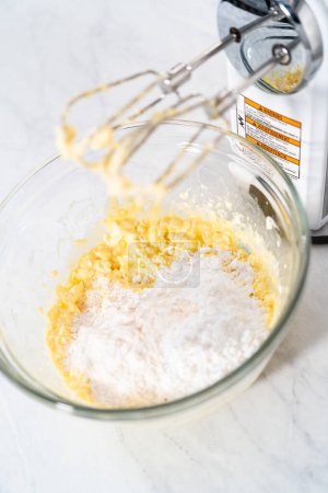 Foto de Mezclar los ingredientes en un tazón de vidrio grande para hacer el relleno de queso crema para la torta de paquete. - Imagen libre de derechos