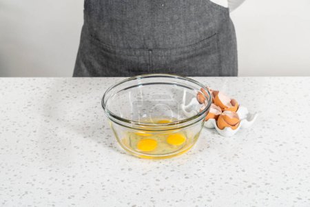 Foto de Mezclar ingredientes húmedos en un tazón de vidrio pequeño para hornear un simple pastel de vainilla. - Imagen libre de derechos