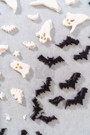 Téléchargez les photos : Remplissage moule en silicone Halloween avec du chocolat fondu pour faire un décor de chocolat pour bretzels. - en image libre de droit