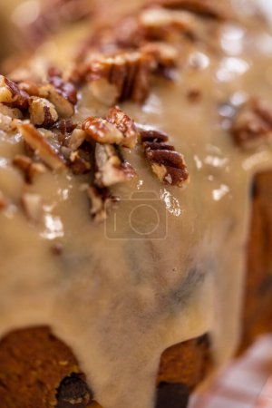 Téléchargez les photos : Gâteau au lapin de citrouille glacé avec glaçage au caramel et garniture de pacanes grillées. - en image libre de droit