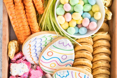 Photo for Assembling charcuterie board with Easter candies, cookies, and marshmallows. - Royalty Free Image